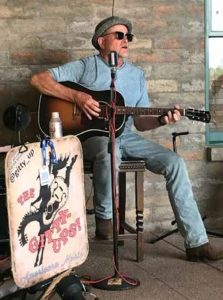 Architect Brian Curley sitting down and playing the guitar